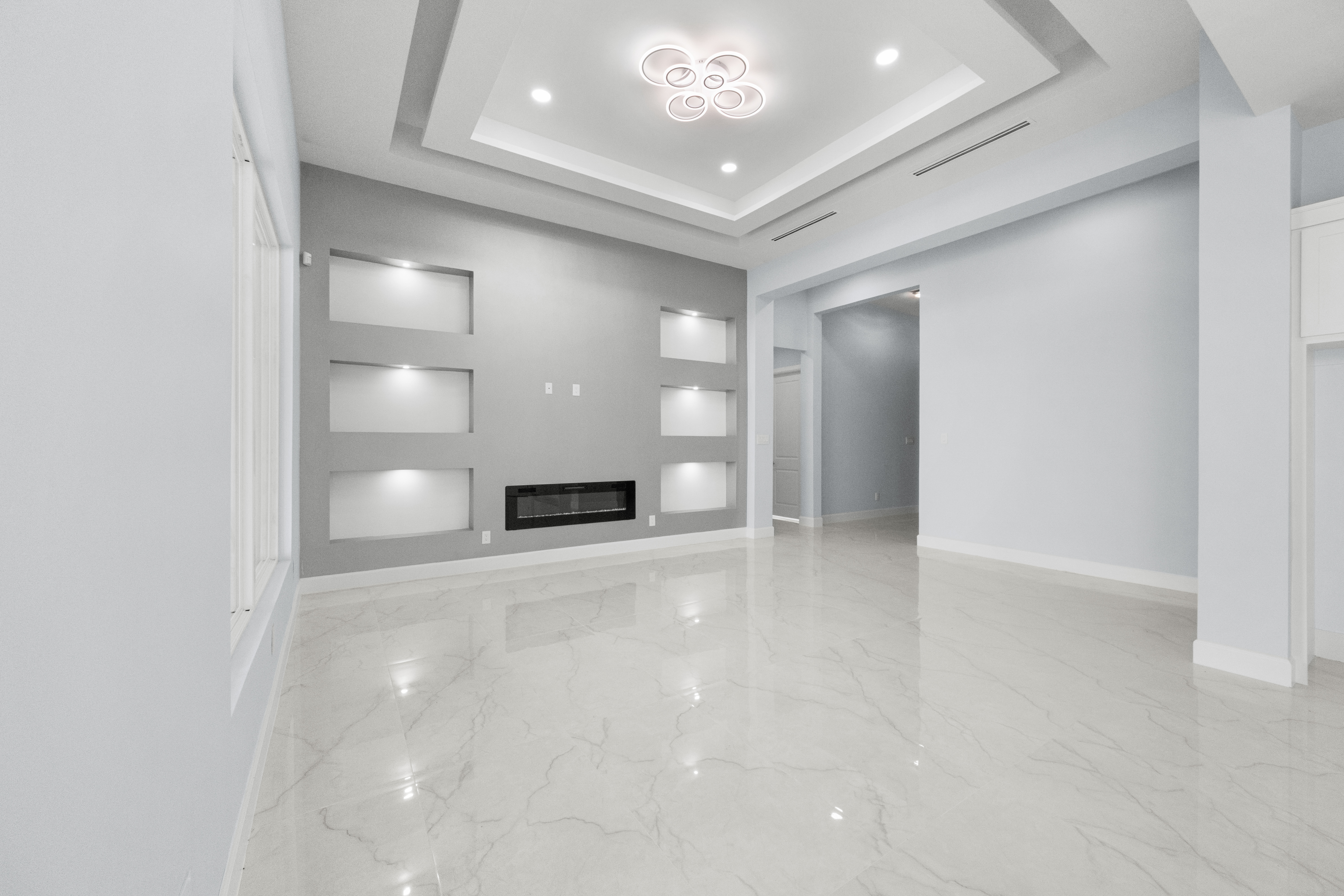 Living room with accent wall, built-in shelves, and linear fireplace