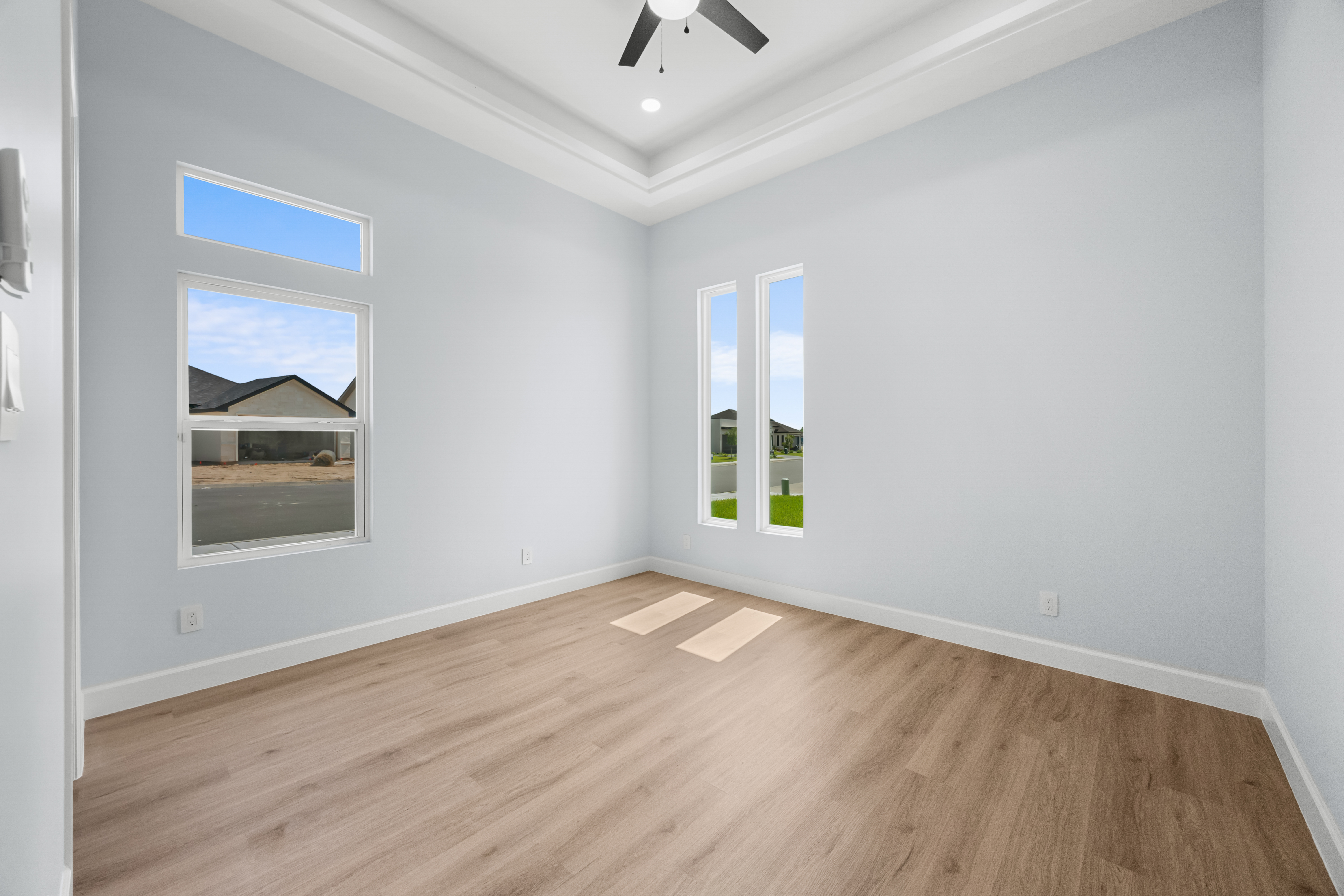 Bedroom with tray ceiling and street view