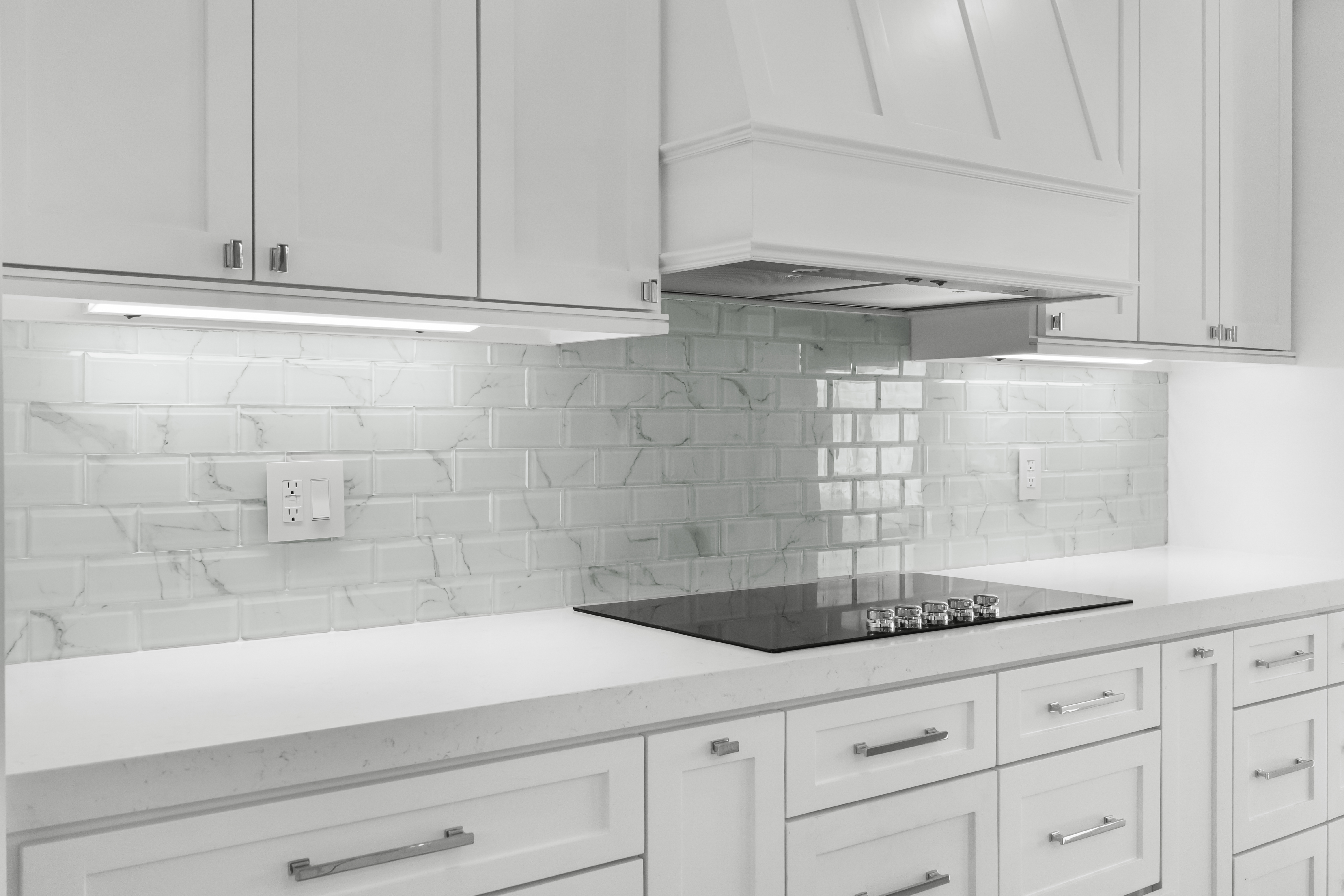 Kitchen cooktop and marble subway backsplash